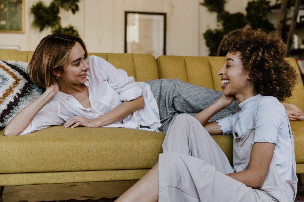 Cheerful lesbian couple talking in a living room